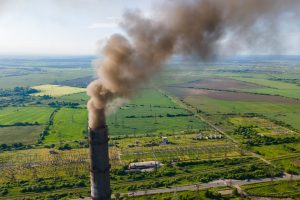 Aerial view of coal power plant high pipes with black smokestack polluting atmosphere and emitting a lot of CO2