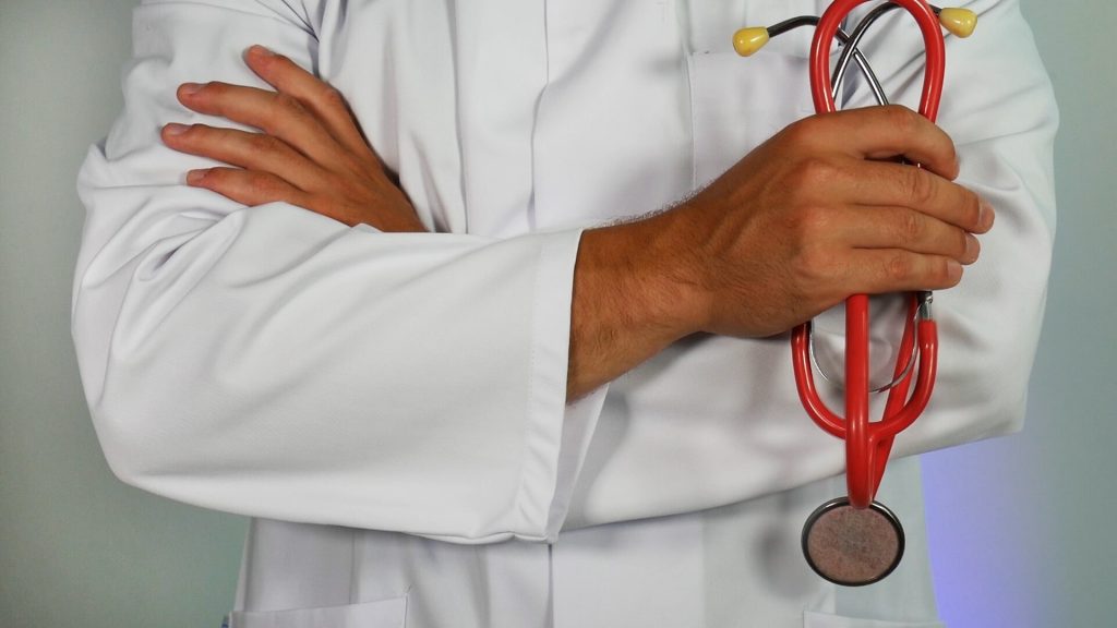 Doctor in a white apron holding a stethoscope